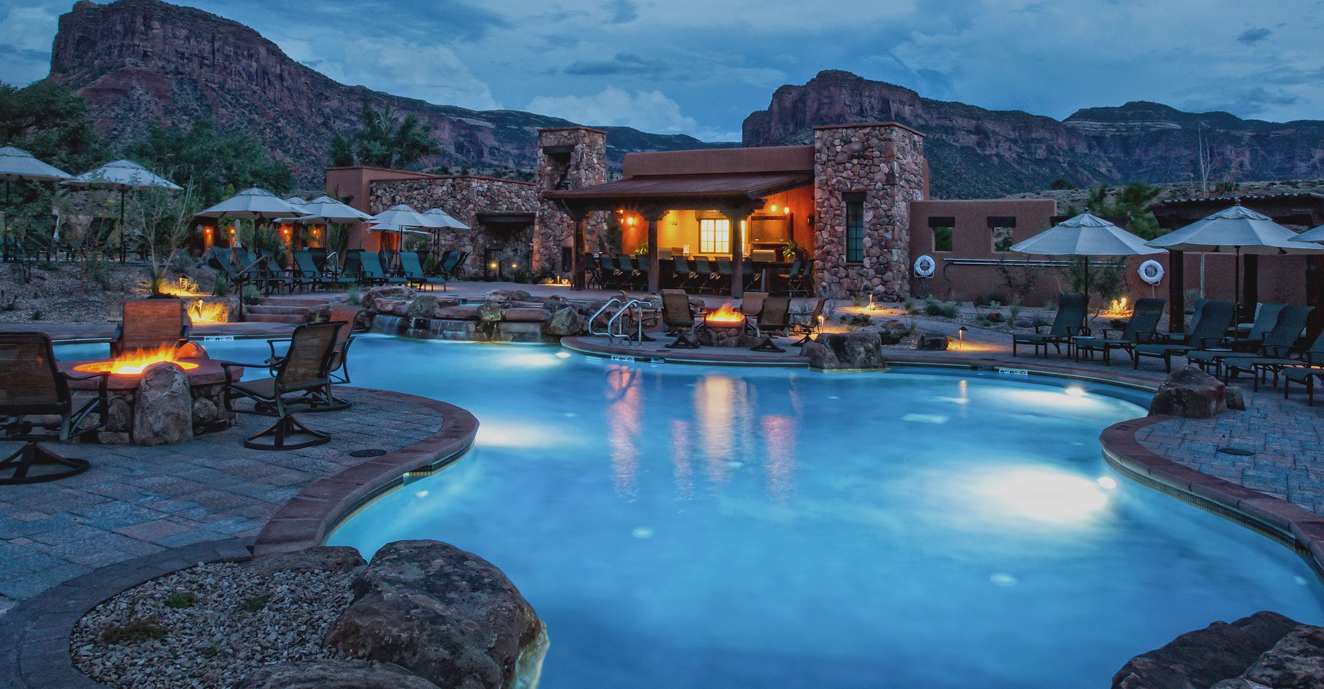 A pool with a mountain view and a house in the background.