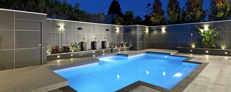 A pool with lights on the side of it