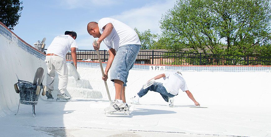 A group of men playing with snow on the ground.