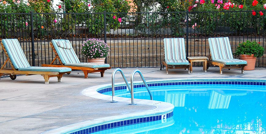 A pool with two chairs and a bench