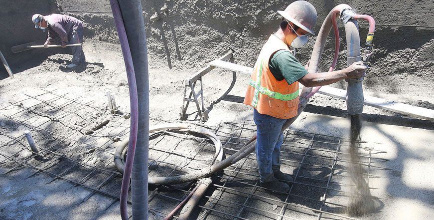 A construction worker is working on the concrete.